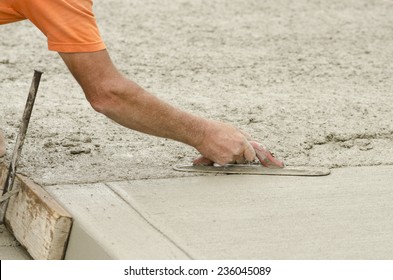 Concrete construction contractor installing a expansion joint in a sidewalk, curb and storm drainage gutter on a new urban road street project