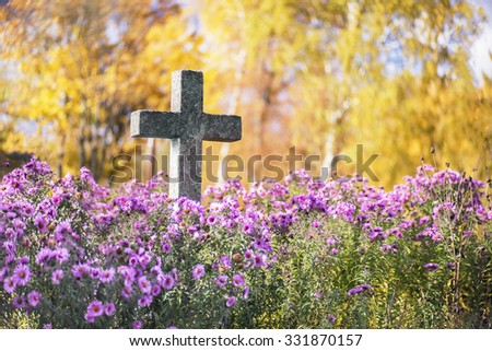 Concrete cross in cemetery in autumn