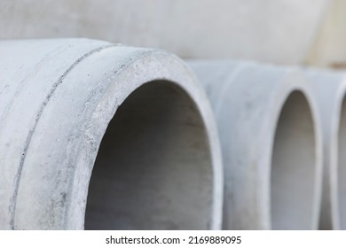 Concrete drainage pipes for wells and water discharges. Building material used for construction close-up. Due to the making process concrete is an unsustainable and not eco-friendly resource - Shutterstock ID 2169889095