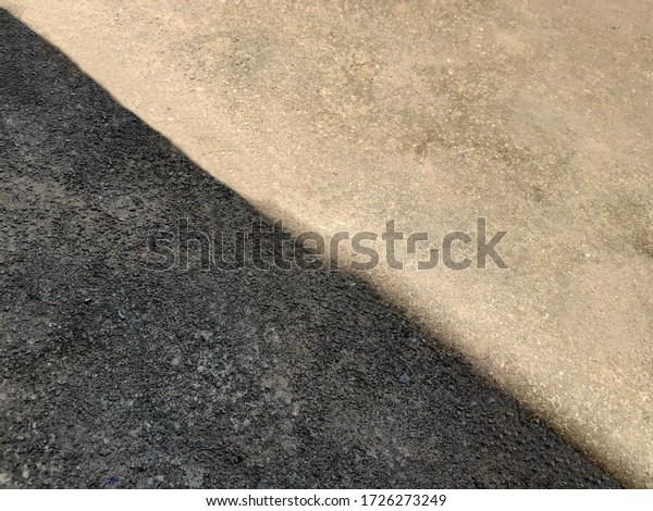 Concrete\
floors background, with right angles, divided into by shadow of the\
house roof, old and stained during the\
day.
