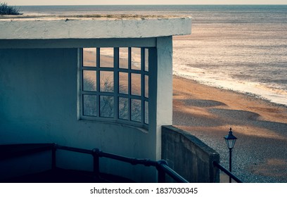 A concrete and glass lookout shelter overlooking the sandy beach at Cromer in Norfolk, UK