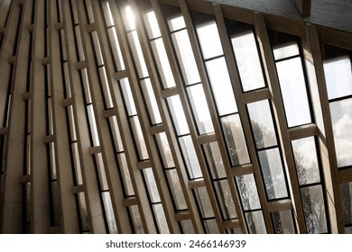 Concrete joists structure with long rectangular vertical windows with black frames. Beautiful view of nature and the sun. Modern architecture with lots of light that invites peace and tranquility.