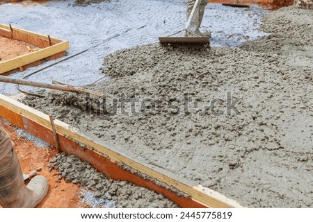 Concrete is leveled by construction worker using special tool