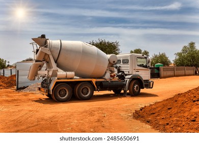 concrete mixer trucks on a dirt road on construction site