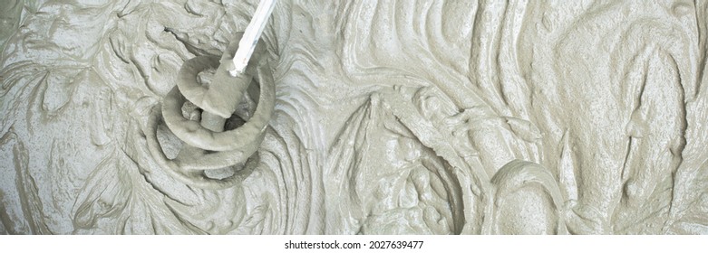 Concrete mixing with electrical drill and mixer, defocused blurred view. Panoramic banner cement mortar texture background - Shutterstock ID 2027639477