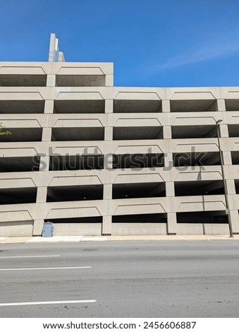 A concrete parking structure with a repeating pattern of rectilinear openings on its facade.