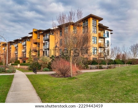 Concrete pathway across green lawn in front of residential condo building
