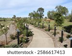 Concrete pathway leading through a rose garden at the Avenue Of Honour in Wandoan, Queensland, Australia