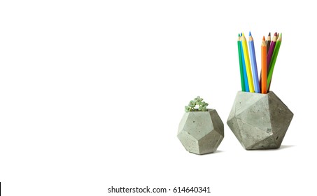 Concrete polygonal vases with succulent plant  and colorful drawing pencils isolated on white.