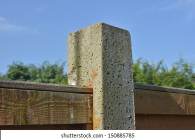 A Concrete Post Holding A Fence Panel.