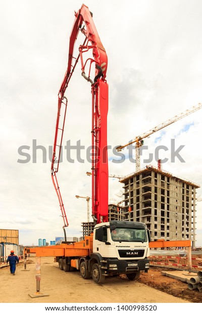 Concrete pump truck\
conveyed concrete on construction site. Construction workers are\
preparing pump for concrete for pouring. Pumping concrete into\
formwork. Moscow 2019