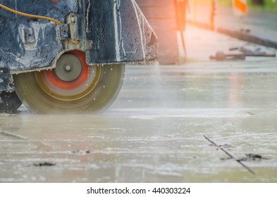 Concrete Road Cutters with worker when raining over the sand truck blurred background, constructor building concept