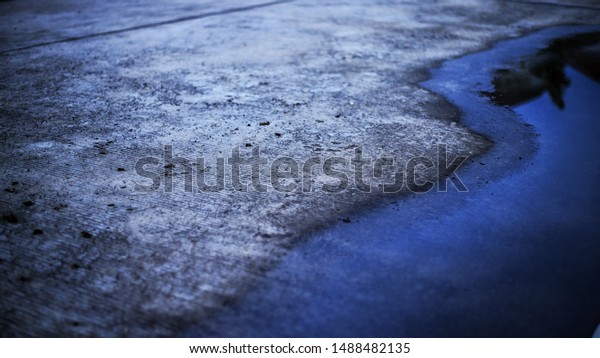 concrete\
road and flooding water. poor drainage system left puddle of\
inundated rain storm water on street\
surface
