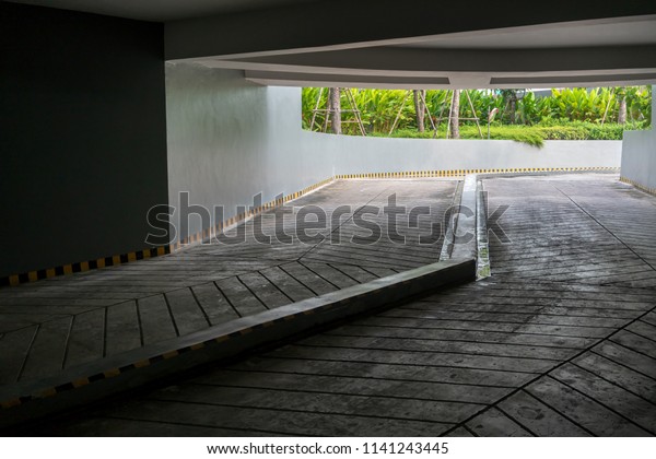 Concrete road and ramp with yellow and black\
curb in building