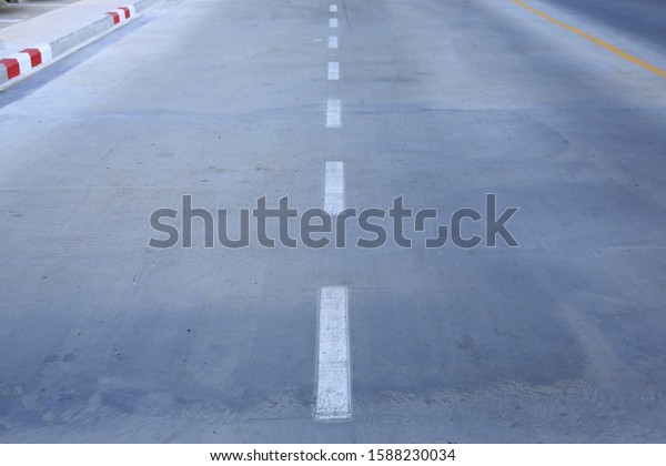 Concrete road with a\
white markings lane.