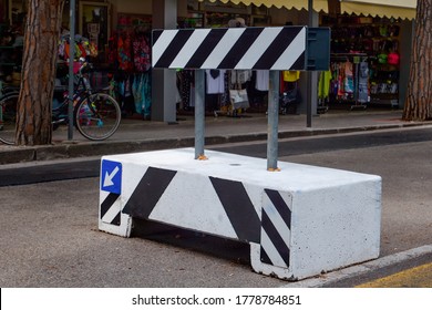 Concrete Roadblock, With Black And White Stripes And An Arrow Showing The Direction Of The Detour