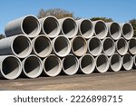 Concrete round big pipes stacked outdoors sewer large heavy water materials new