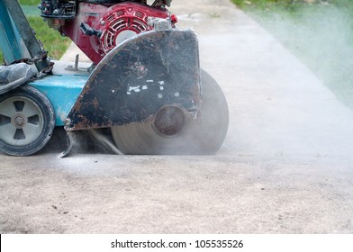 A Concrete Saw On A Cart Cutting Through Sidewalk