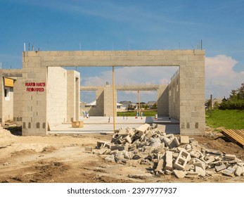 Concrete shell of garage attached to single-family house under construction, with 