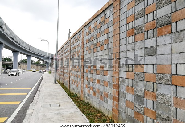 Concrete sound barrier wall next to busy\
highway and elevated rail track, isolate\
noise.
