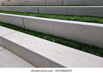 concrete staircase is new and smooth. seating stairs for students and people in the park. lawn benches and beds with perennials in combination with building element, auditorium, school yard, classroom