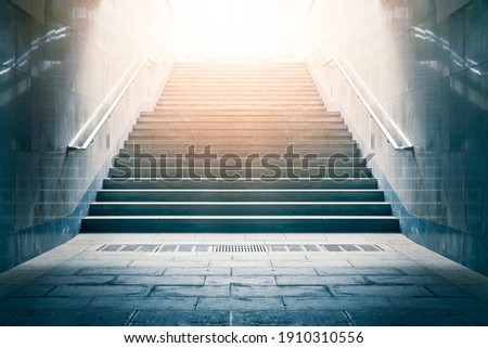 Concrete stairs leading up towards light. Concept of hope and bright future