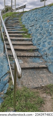 The concrete stairs are steep, with aluminum handrails. prevent slipping