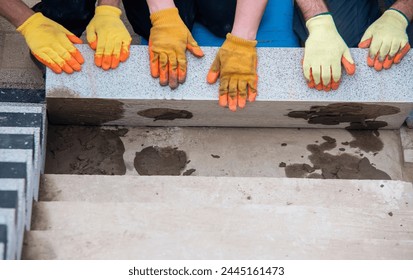 Concrete steps under construction as a team of builders install heavy concrete blocks