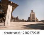 A concrete structure with tall pillars in sunlight