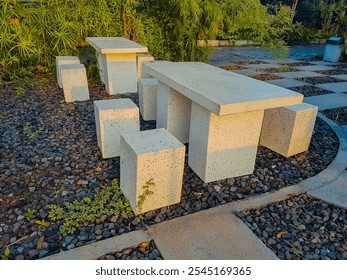 Concrete table and chairs geometric shapes outdoor. Plaster cast table and chair in the garden.

 - Powered by Shutterstock