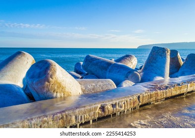 Concrete tetrapod blocks covered with ice on nice winter day at a breakwater on Black Sea coast,Varna beach ,Bulgaria
