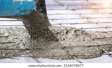 Concrete Truck Chute Pouring Wet Cement Mix into a floor