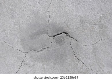 Concrete wall with cracks in it. Cracked concrete coating on the wall.