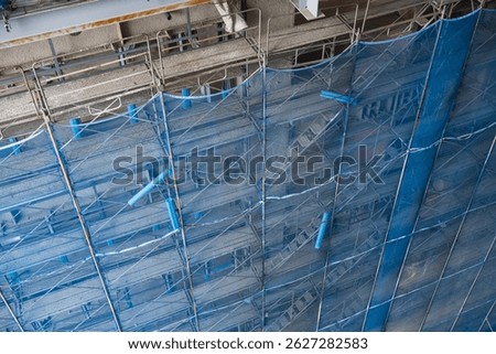 Concrete wall under construction with net protection