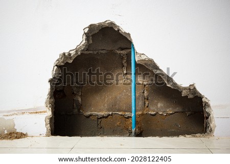 Concrete walls in the shade that have been smashed or destroyed to find holes for water leaks. Home repair concept.