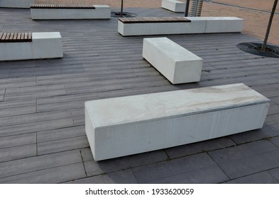 Concrete White Bench Block And Wave Shape In The Park On A Dark Cobbled Square, Clean Concrete Surface Gray Brown White Pedestrian And Rest Area At The Skate Park For Young People, Teenagers