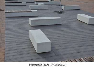 Concrete White Bench Block And Wave Shape In The Park On A Dark Cobbled Square, Clean Concrete Surface Gray Brown White Pedestrian And Rest Area At The Skate Park For Young People, Teenagers