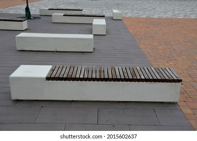 Concrete White Bench Block And Wave Shape In The Park On A Dark Cobbled Square, Clean Concrete Surface Gray Brown White Pedestrian And Rest Area At The Skate Park For Young People, Teenagers