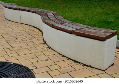 Concrete White Bench Block And Wave Shape In The Park On A Dark Cobbled Square, Clean Concrete Surface Gray Brown White Pedestrian And Rest Area At The Skate Park For Young People, Teenagers