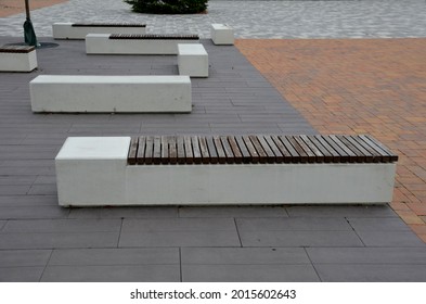 Concrete White Bench Block And Wave Shape In The Park On A Dark Cobbled Square, Clean Concrete Surface Gray Brown White Pedestrian And Rest Area At The Skate Park For Young People, Teenagers