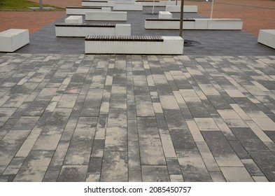 Concrete White Bench Block And Wave Shape In The Park On A Dark Cobbled Square, Clean Concrete Surface Gray Brown White Pedestrian And Rest Area At The Skate Park For Young People, Teenagers