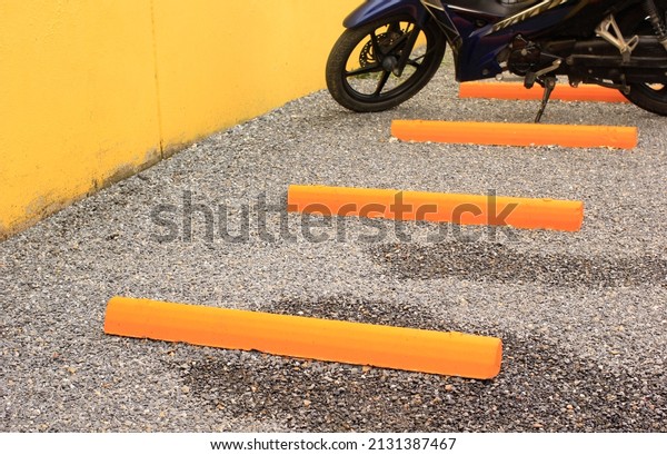 Concrete\
yellow dividing line for motorcycle\
parking.