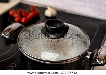 condensation drops on the glass lid of the kitchen pot boiling 