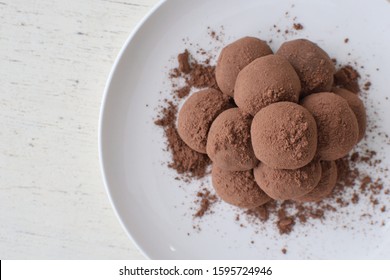 Condensed Milk Chocolate Truffles On White Paper And On White Wood Table.