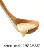 condensed milk in wooden ladle isolated on white background