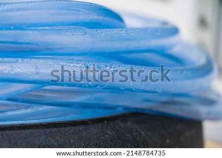 Condensed water droplets in a clear blue hose.