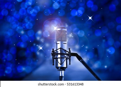 Condenser microphone with blue bokeh background.High quality microphone standing on  karaoke stage ready for joyful christmas party and celebration. - Powered by Shutterstock