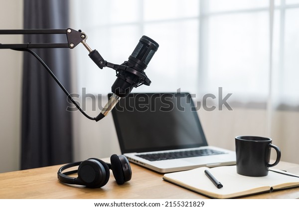 Condenser\
microphone in recording home studio. Content creator working with\
laptop host streaming radio podcast interview conversation at home\
broadcast studio recording voice over\
radio