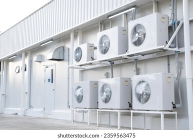 Condenser unit or compressor install side industrial plant building. Unit of central air conditioner (AC) or heating ventilation air conditioning system (HVAC). Pump and fan inside.