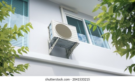 Condenser Unit Or Compressor Outside Home Or Residential Building. Unit Of Central Air Conditioner (AC) Or Heating Ventilation Air Conditioning System (HVAC). Electric Fan And Refrigerant Pump Inside.